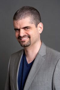 Smiling Dr. Bernardo Kastrup in a professional suit and tie.