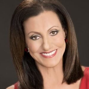 A photograph of Dianne Collins, a woman with dark hair and a red dress.