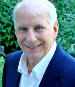 Dr. Peter Breggin, in a suit and white shirt, smiling warmly.